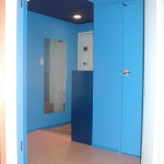 玄関のドアには水色のシート。下駄箱は少し濃いめの青を塗り、 絨毯はフローリングに。天井は紺の壁紙。横と梁は青い壁紙。玄関を開けると 青い空間が飛び込んできます。